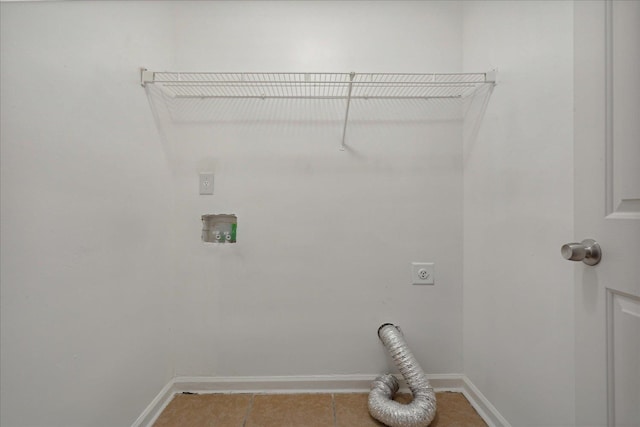 clothes washing area featuring electric dryer hookup and light tile patterned flooring