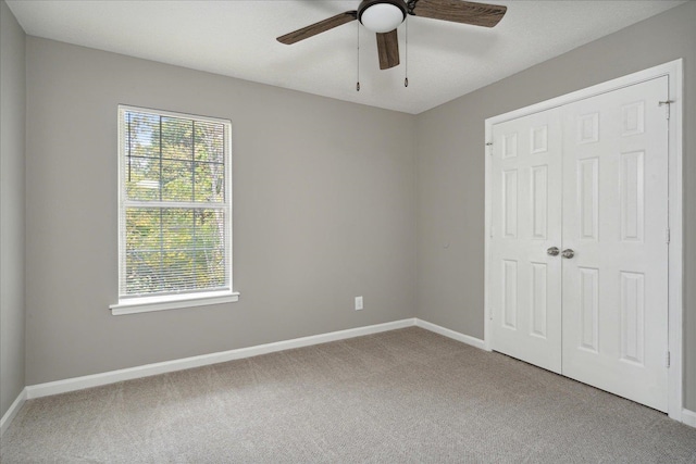 unfurnished bedroom with carpet flooring, a closet, and ceiling fan