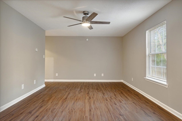 unfurnished room featuring dark hardwood / wood-style flooring, ceiling fan, and plenty of natural light