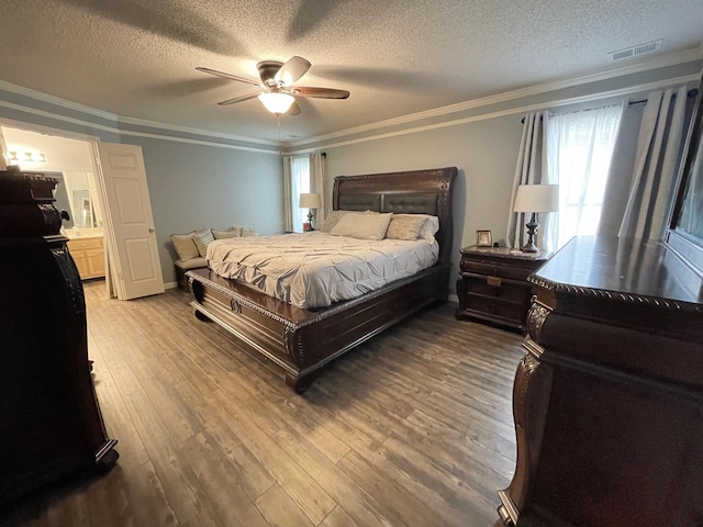 bedroom with a textured ceiling, wood-type flooring, ceiling fan, and crown molding