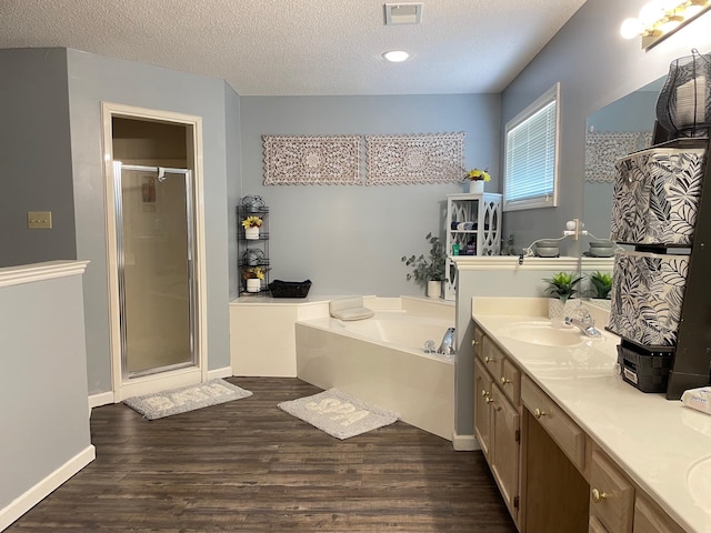 bathroom featuring hardwood / wood-style floors, vanity, a textured ceiling, and separate shower and tub