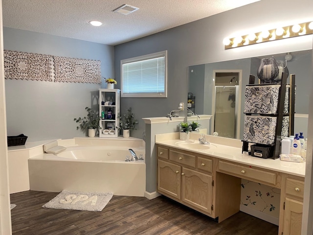 bathroom featuring vanity, a textured ceiling, plus walk in shower, and wood-type flooring