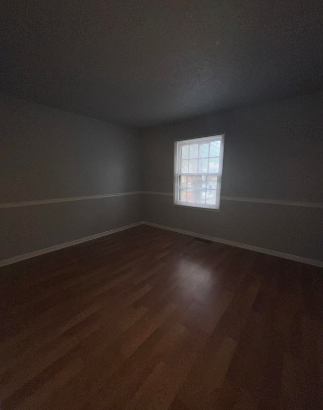 empty room featuring dark hardwood / wood-style flooring