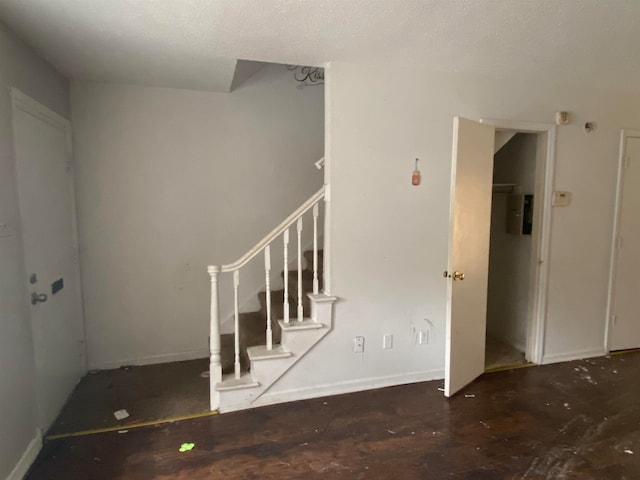 staircase with a textured ceiling