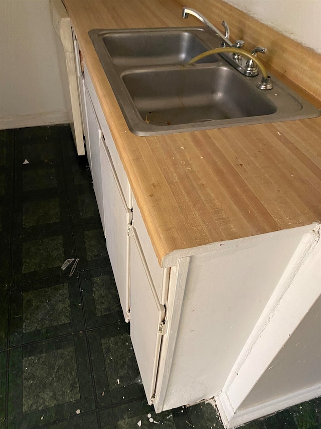 kitchen featuring dark tile patterned flooring and sink