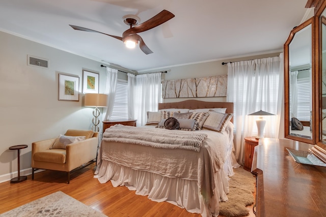 bedroom featuring ornamental molding, light hardwood / wood-style floors, and ceiling fan