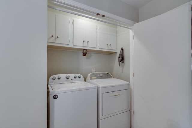 washroom with separate washer and dryer and cabinets