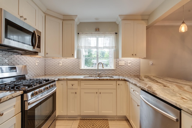 kitchen featuring light stone countertops, sink, appliances with stainless steel finishes, and decorative backsplash