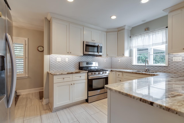 kitchen with appliances with stainless steel finishes, light stone countertops, sink, and backsplash