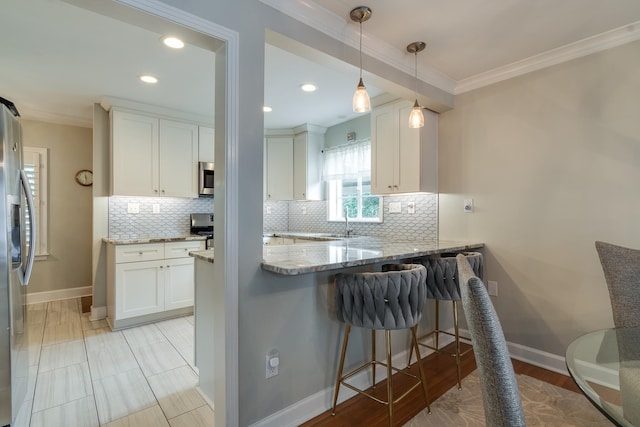 kitchen featuring white cabinetry, light stone counters, and stainless steel appliances