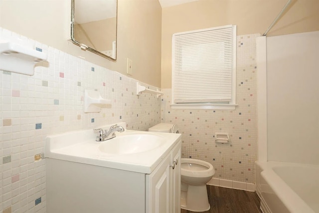 full bathroom featuring tile walls, vanity, hardwood / wood-style floors, and toilet