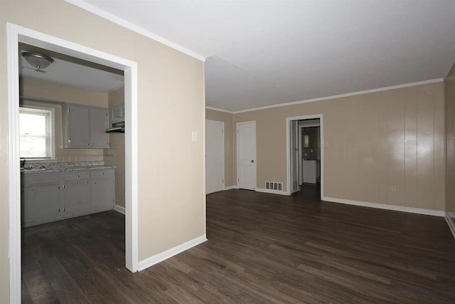 spare room with crown molding and dark hardwood / wood-style flooring