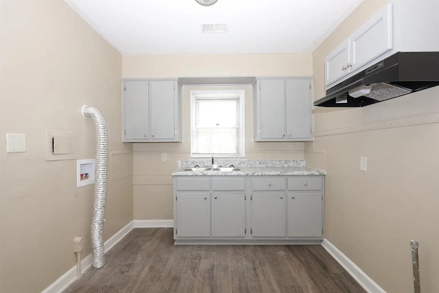 clothes washing area with cabinets, washer hookup, dark hardwood / wood-style floors, and sink