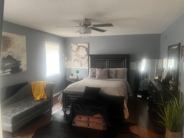 bedroom featuring a textured ceiling, dark wood-type flooring, and ceiling fan