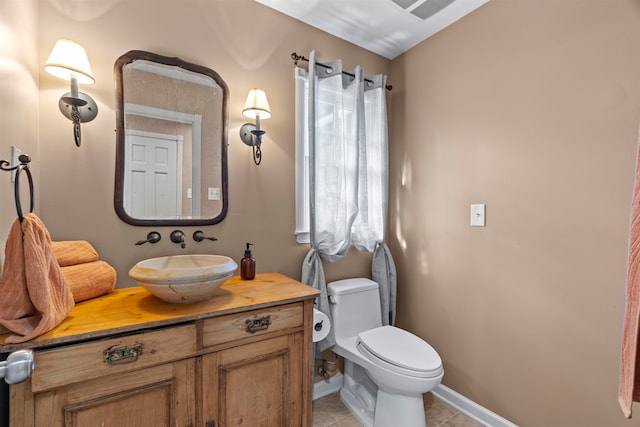 bathroom featuring toilet, vanity, and tile patterned flooring