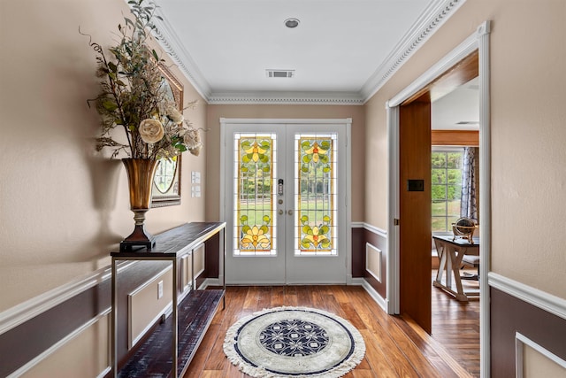 doorway to outside with french doors, crown molding, and wood-type flooring