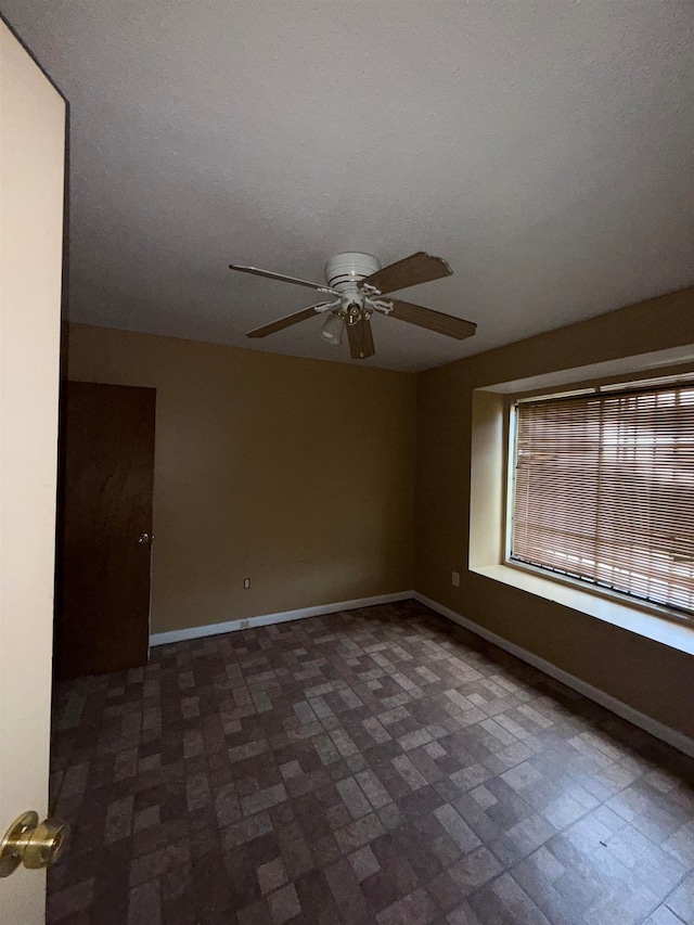 spare room with a textured ceiling and ceiling fan