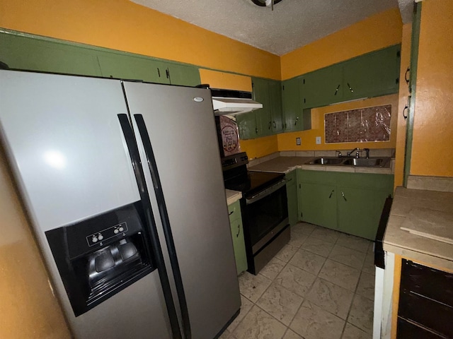 kitchen with range with electric cooktop, green cabinets, stainless steel fridge, sink, and a textured ceiling