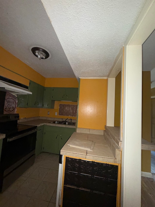 kitchen featuring dark tile patterned flooring, extractor fan, black range with electric cooktop, sink, and a textured ceiling