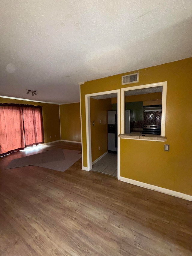 unfurnished room featuring a textured ceiling and light hardwood / wood-style flooring