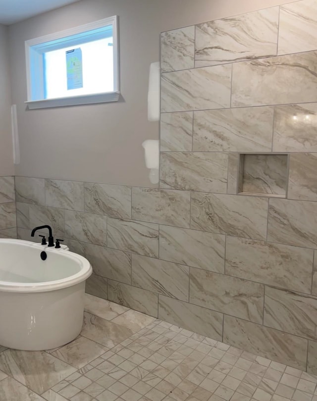 bathroom with a bathing tub and tile walls