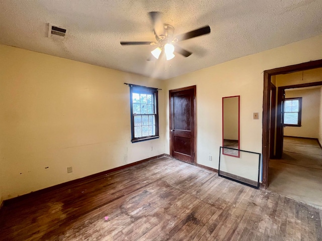 unfurnished bedroom featuring ceiling fan, a textured ceiling, and hardwood / wood-style floors