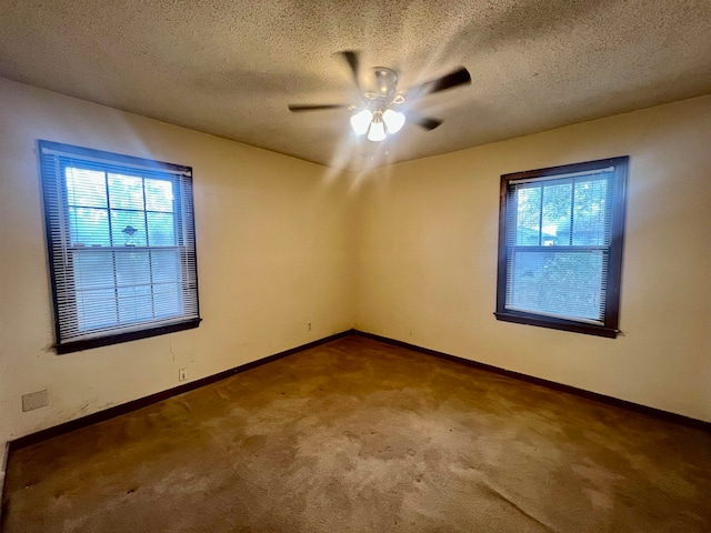 empty room with a textured ceiling, a healthy amount of sunlight, and ceiling fan