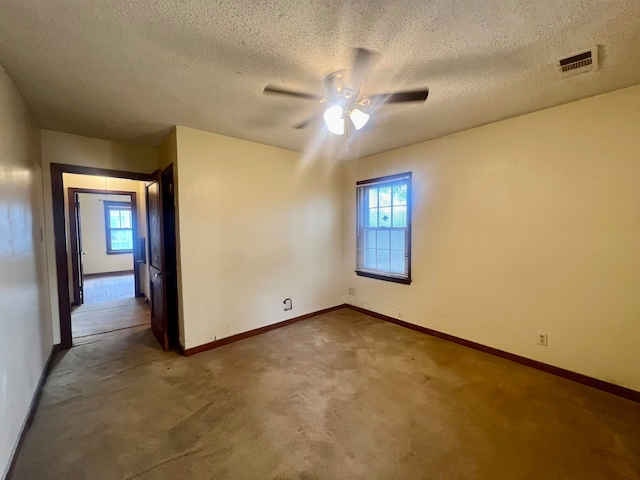 unfurnished room featuring ceiling fan, a textured ceiling, a wealth of natural light, and carpet floors