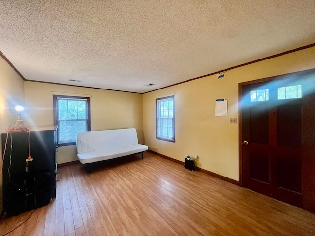 unfurnished bedroom with a textured ceiling, crown molding, and wood-type flooring