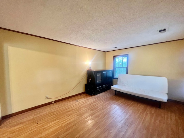 unfurnished bedroom with ornamental molding, hardwood / wood-style floors, and a textured ceiling