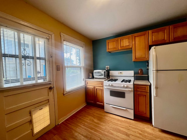 kitchen featuring light wood-type flooring and white appliances