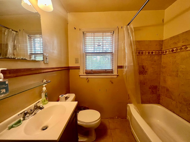 full bathroom featuring vanity, shower / bath combo with shower curtain, toilet, and tile patterned flooring