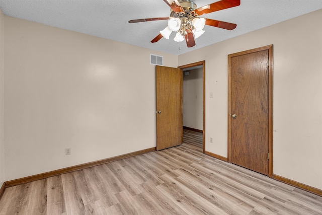 unfurnished bedroom featuring ceiling fan, a textured ceiling, and light hardwood / wood-style flooring