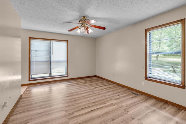 empty room featuring light hardwood / wood-style floors, a textured ceiling, and ceiling fan