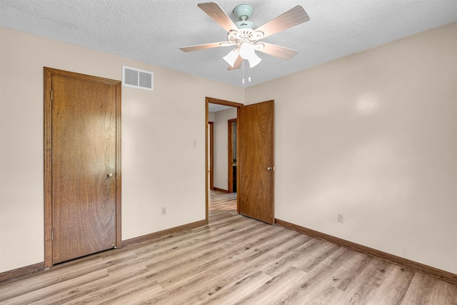 unfurnished bedroom featuring ceiling fan, a textured ceiling, and light wood-type flooring