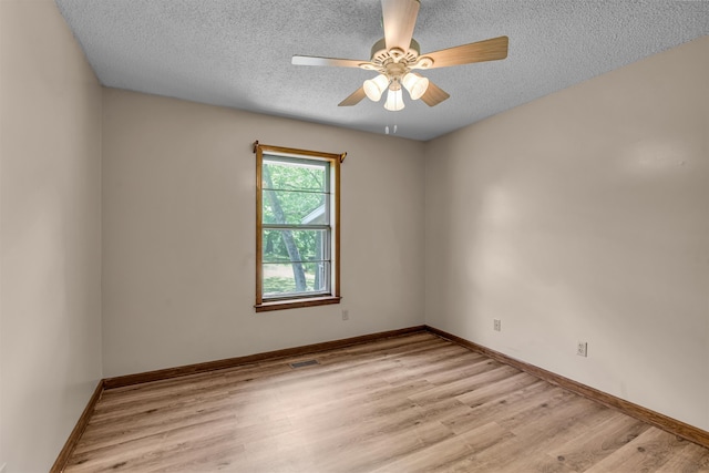 empty room featuring light hardwood / wood-style flooring, a textured ceiling, and ceiling fan