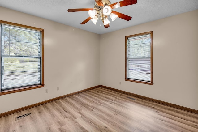 9430 Monasco Rd, Millington, TN 38053 - unfurnished room with light wood-type flooring, baseboards, ceiling fan, and a textured ceiling