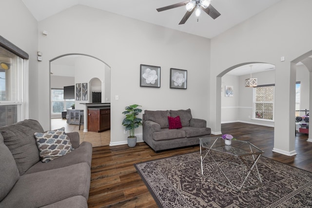 living room with ceiling fan, dark wood-type flooring, and high vaulted ceiling