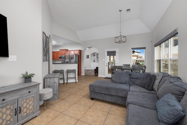 tiled living room featuring high vaulted ceiling