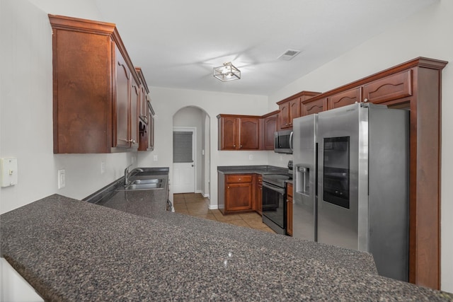 kitchen with kitchen peninsula, sink, light tile patterned flooring, and stainless steel appliances