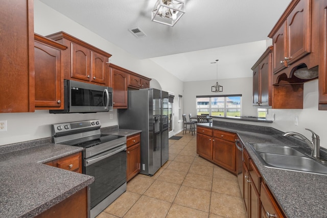 kitchen featuring light tile patterned flooring, appliances with stainless steel finishes, decorative light fixtures, and sink