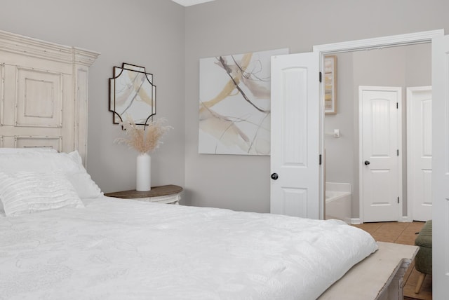 bedroom with light tile patterned floors and connected bathroom