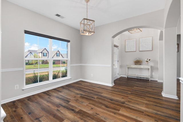 unfurnished dining area with dark hardwood / wood-style flooring and a notable chandelier