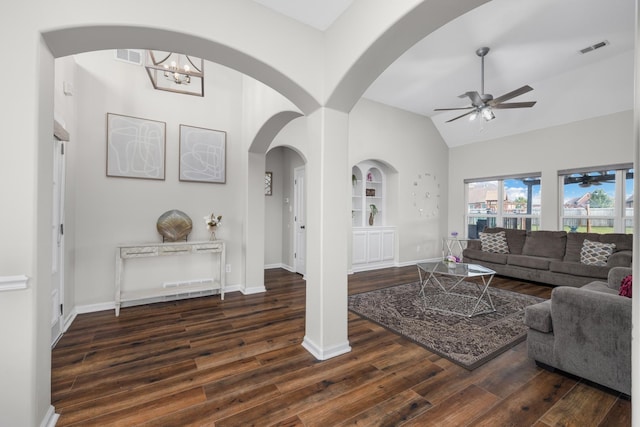 living room featuring lofted ceiling, built in features, ceiling fan with notable chandelier, and dark hardwood / wood-style floors