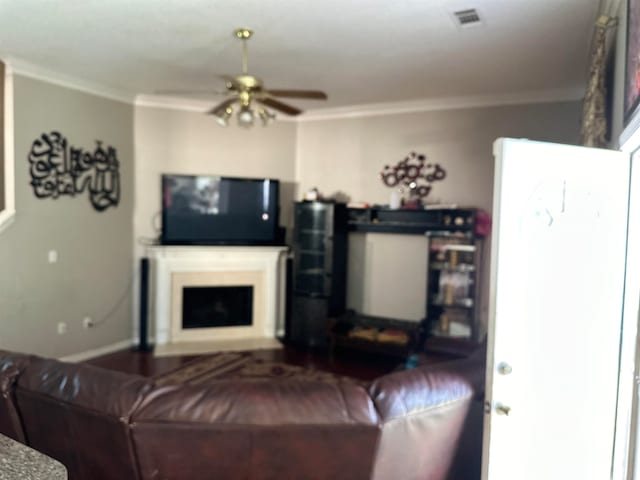 living room with crown molding and ceiling fan