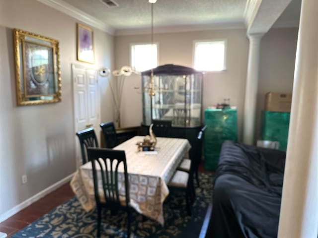 dining room featuring ornamental molding, hardwood / wood-style floors, and decorative columns