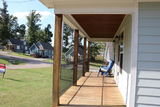 wooden deck featuring a lawn