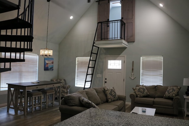 living room with a barn door, dark hardwood / wood-style floors, an inviting chandelier, and high vaulted ceiling