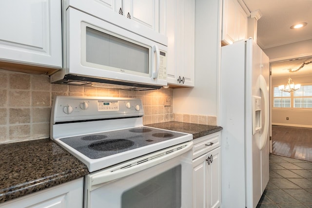 kitchen with white appliances, backsplash, an inviting chandelier, white cabinets, and dark tile patterned floors