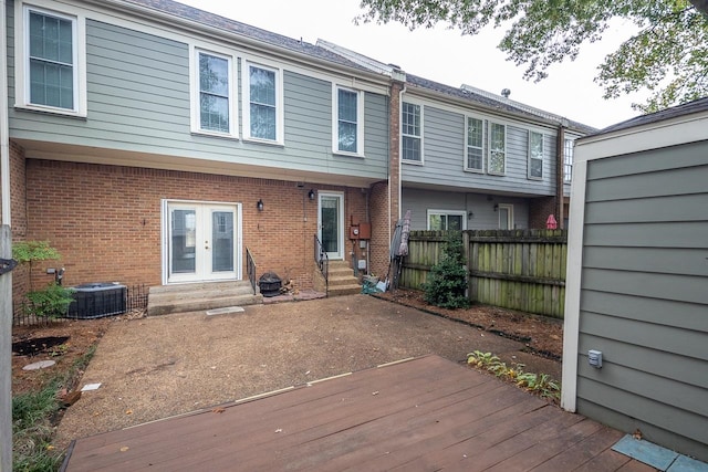 rear view of property with central AC unit, a deck, and french doors